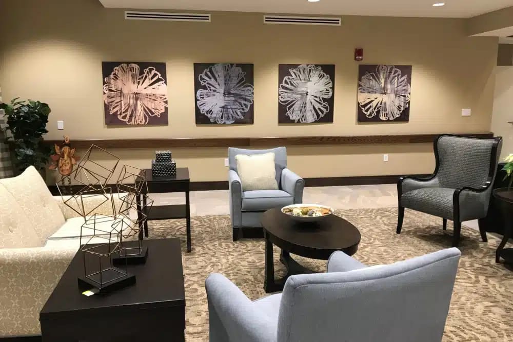 Living room with blue and beige seating, decorative artwork, and a coffee table