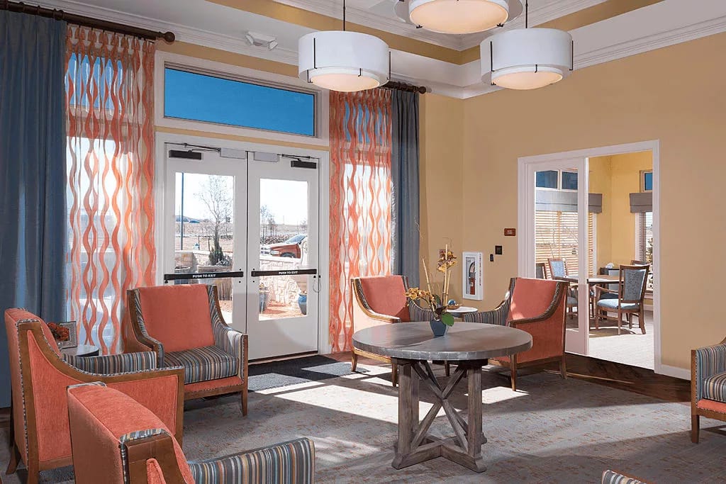 Lobby seating area with vibrant curtains and a round table