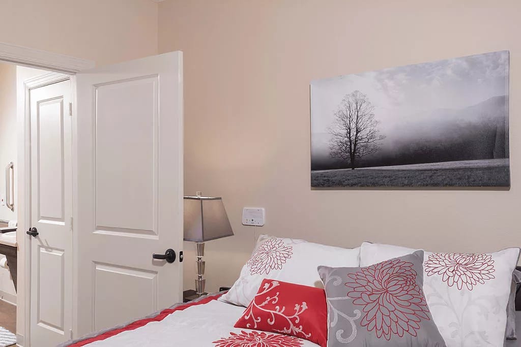 Well-decorated bedroom with a bed, lamp, and wall art.