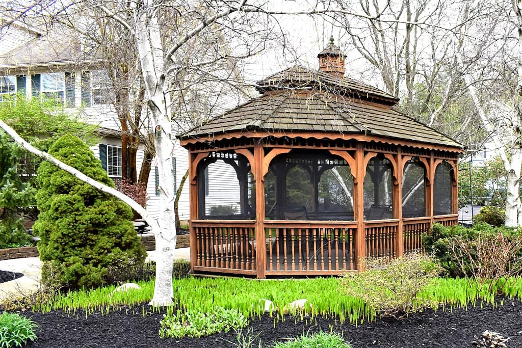 Wooden gazebo surrounded by greenery