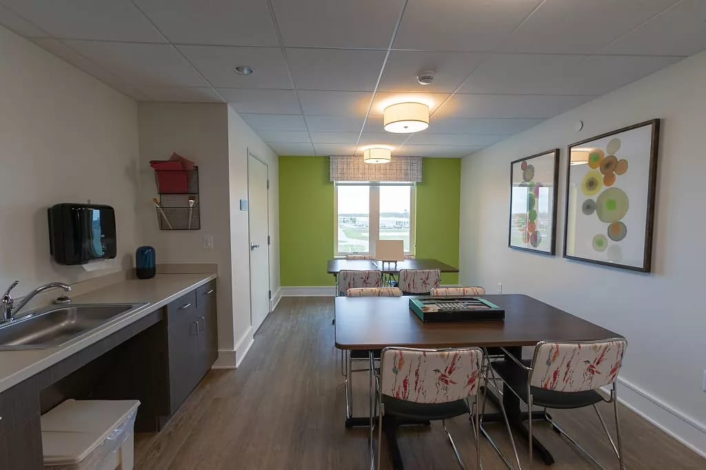 Modern common area with dining table and kitchen sink.
