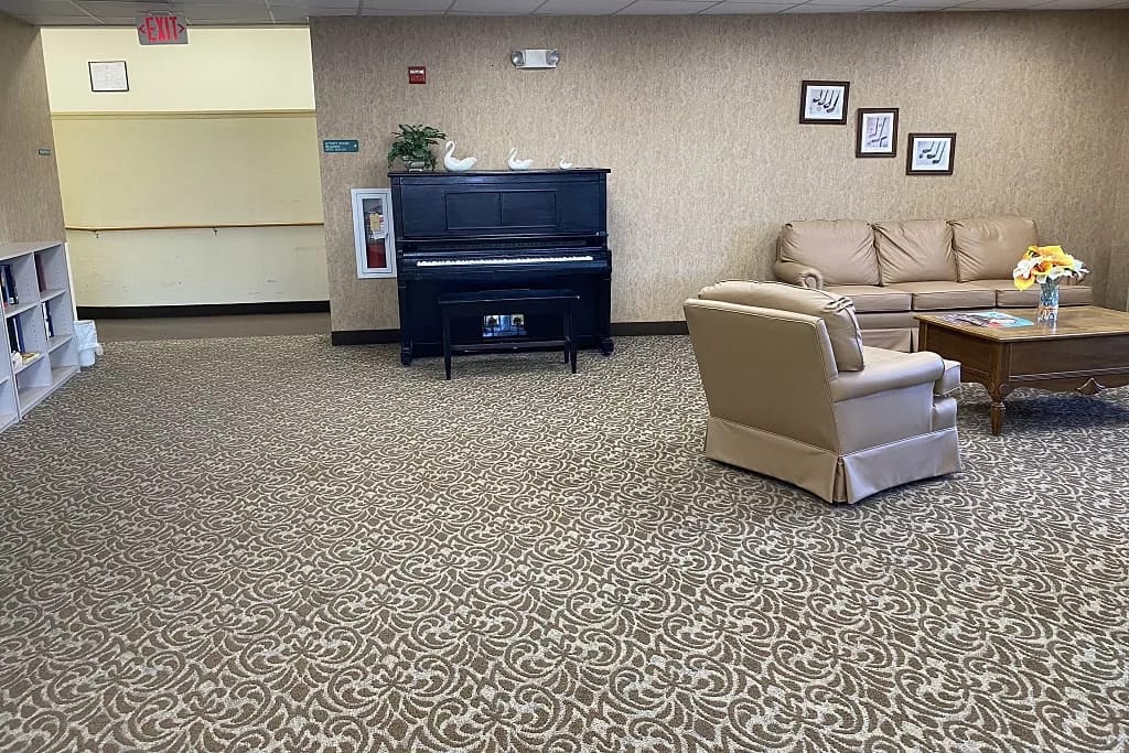 Living room with seating, piano, and decorative elements