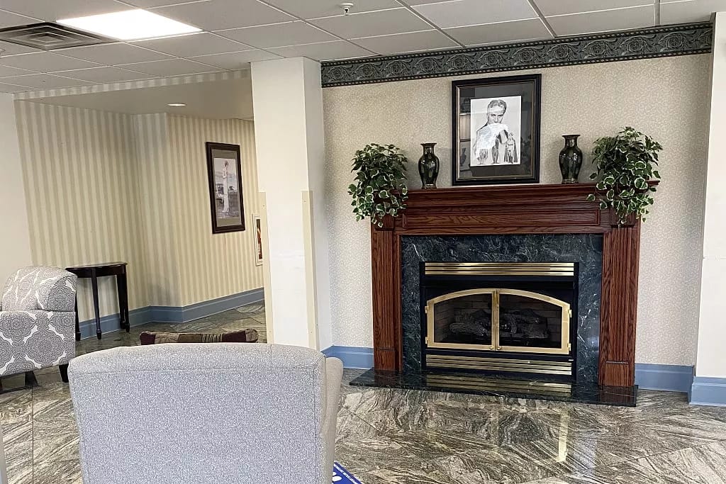 Living room area featuring a fireplace, plants, and seating.