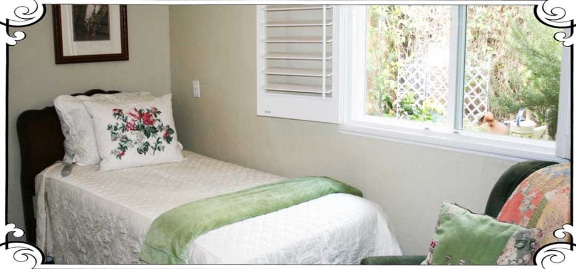 A cozy bedroom with a single bed, decorative pillow, and window view
