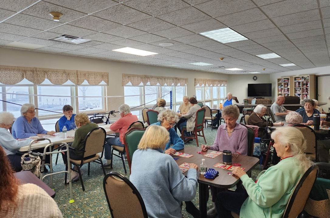 Residents playing bingo in a spacious community room.