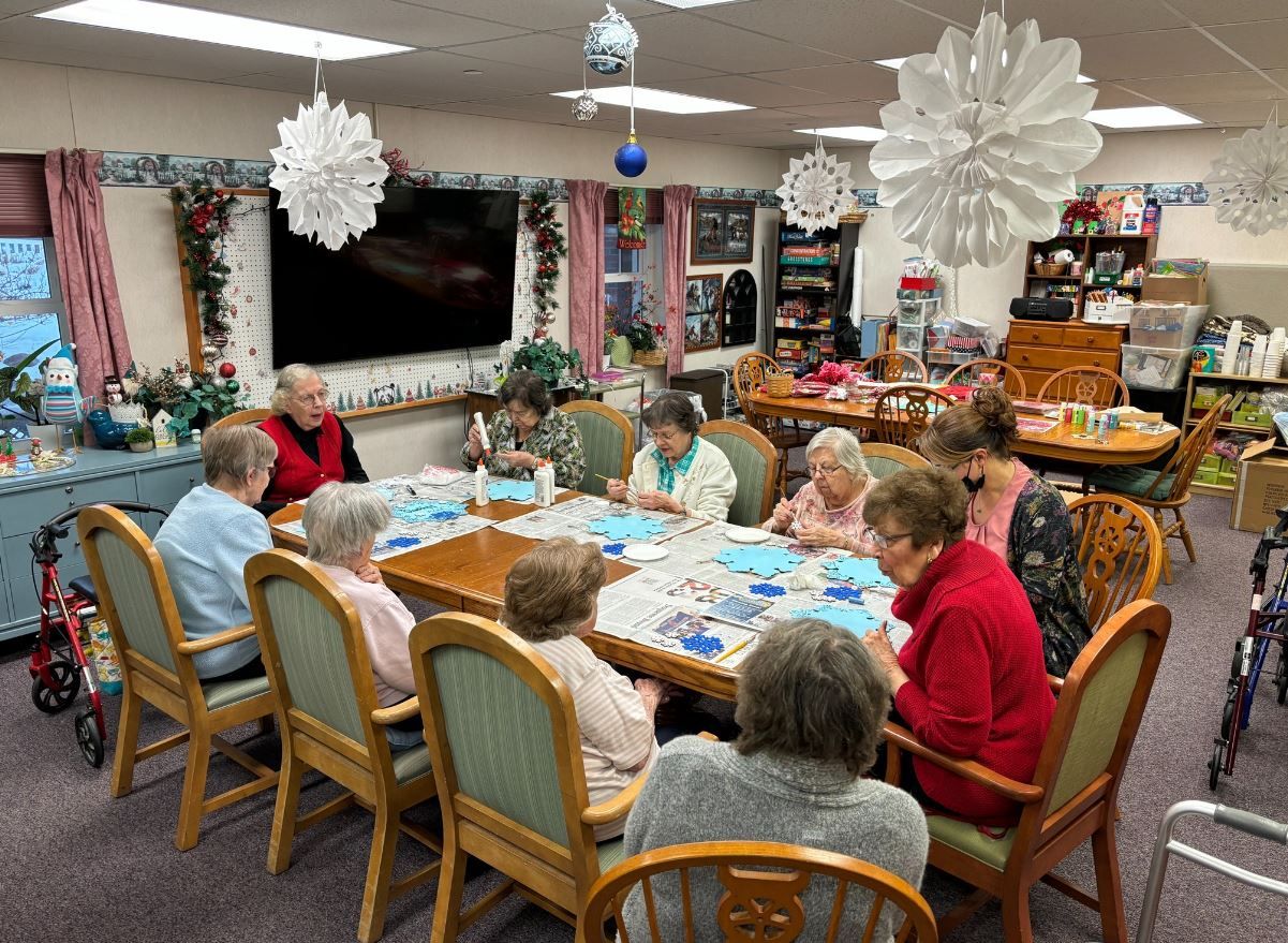 Seniors engaged in an art activity around a table at Orchard Grove