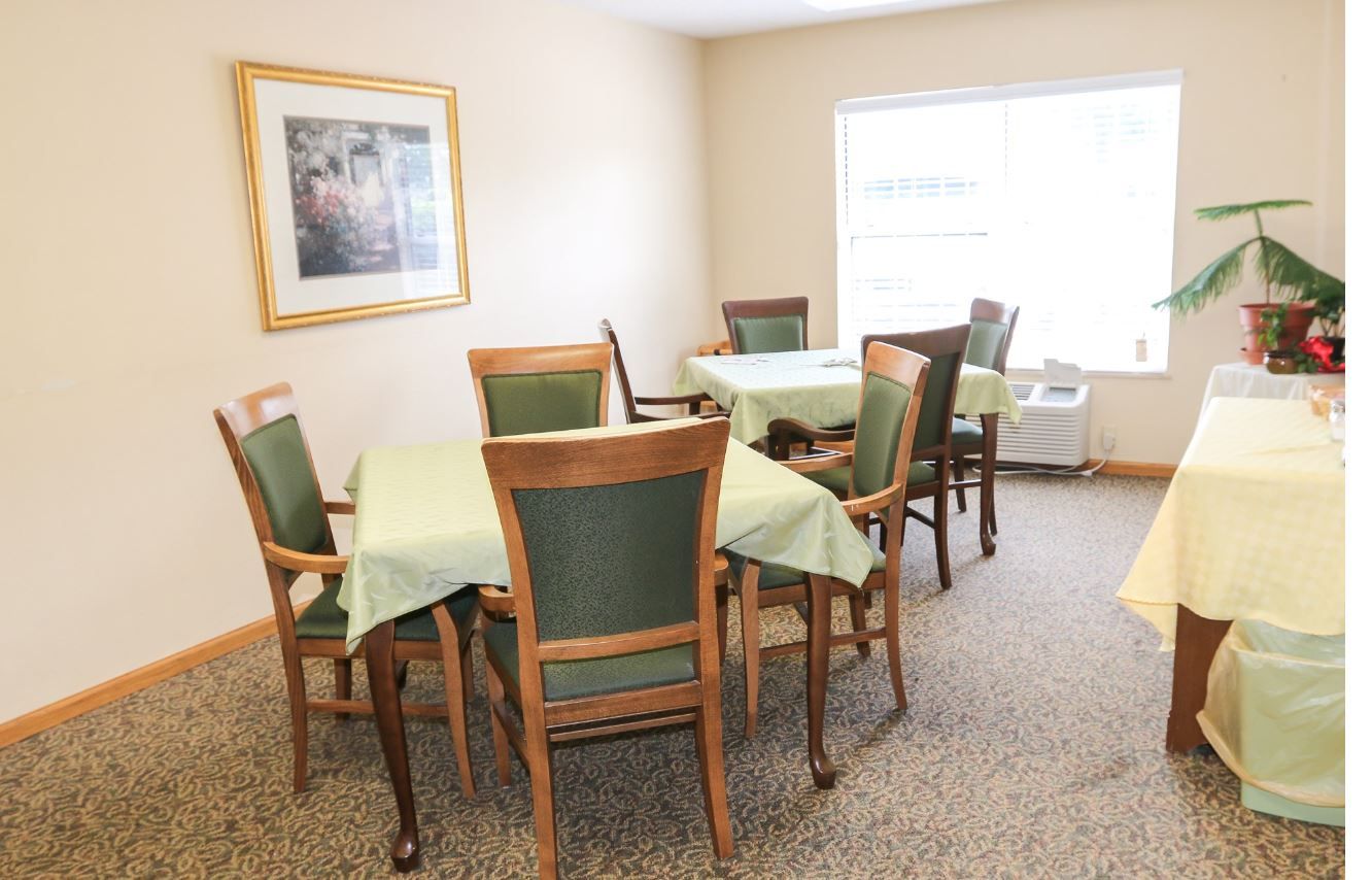 Cozy dining area with green tablecloths and wooden chairs