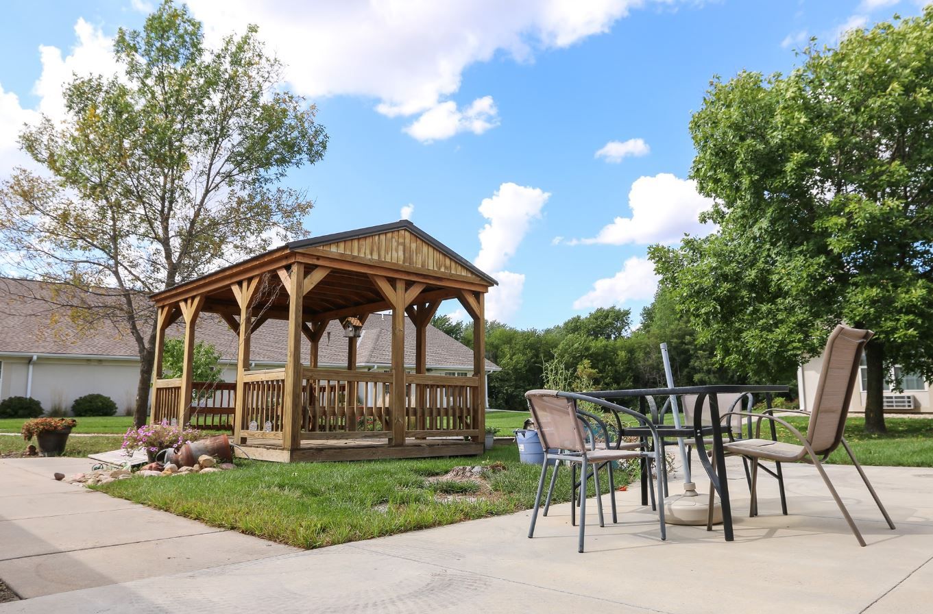 Wooden gazebo with outdoor seating area and landscaping