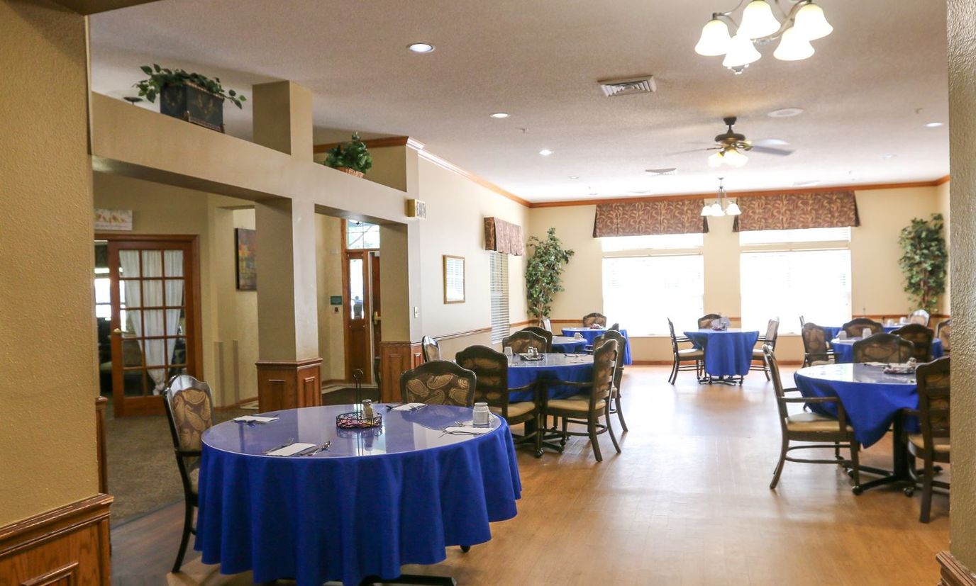 Dining room with blue tablecloths and wooden chairs