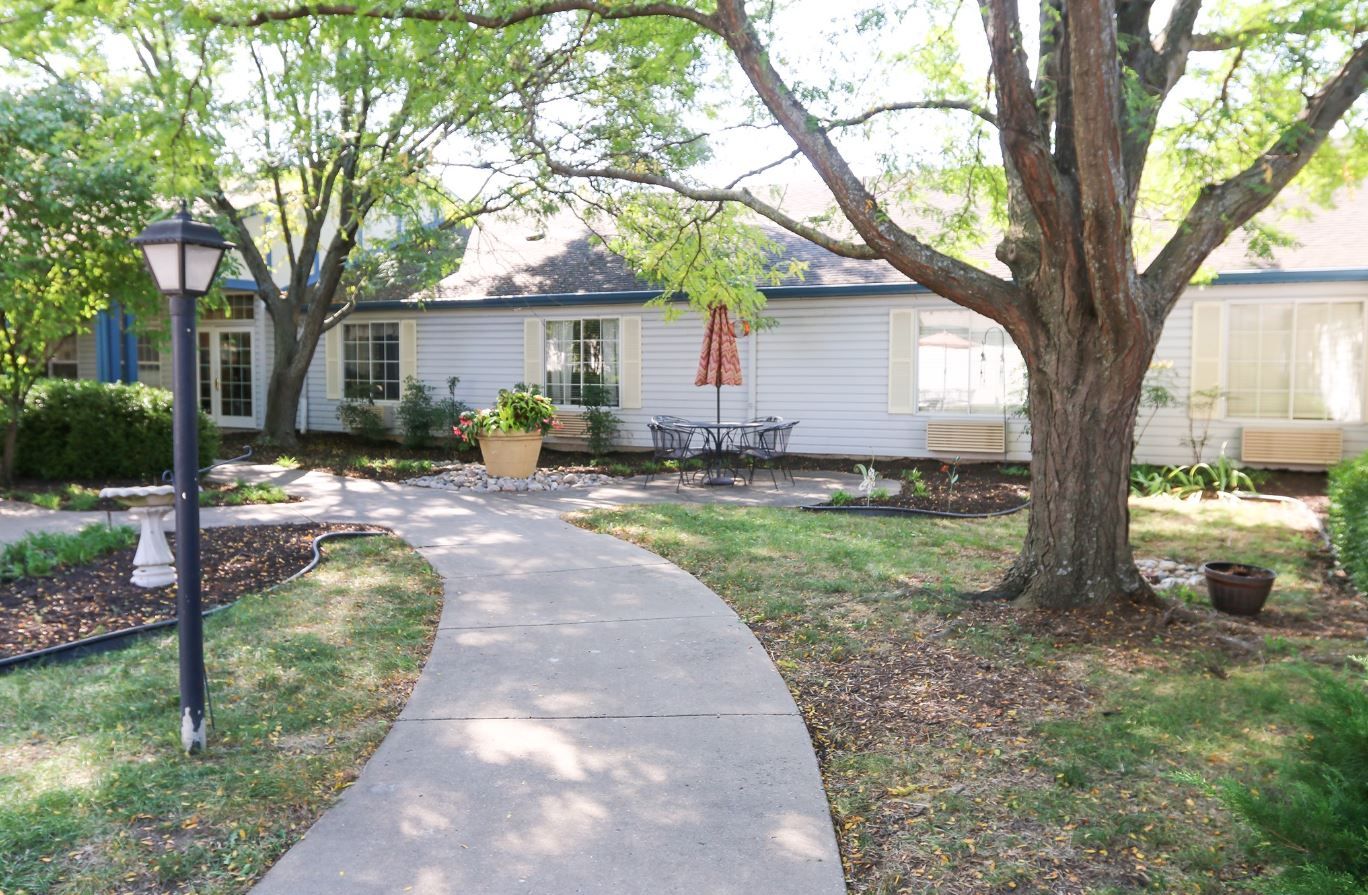 A winding path through a landscaped garden with seating area.