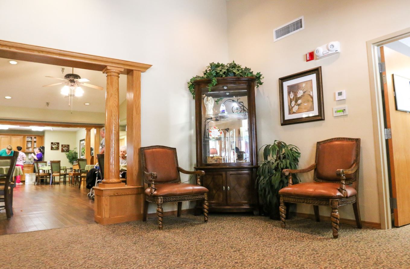 Living area featuring brown chairs and display cabinet