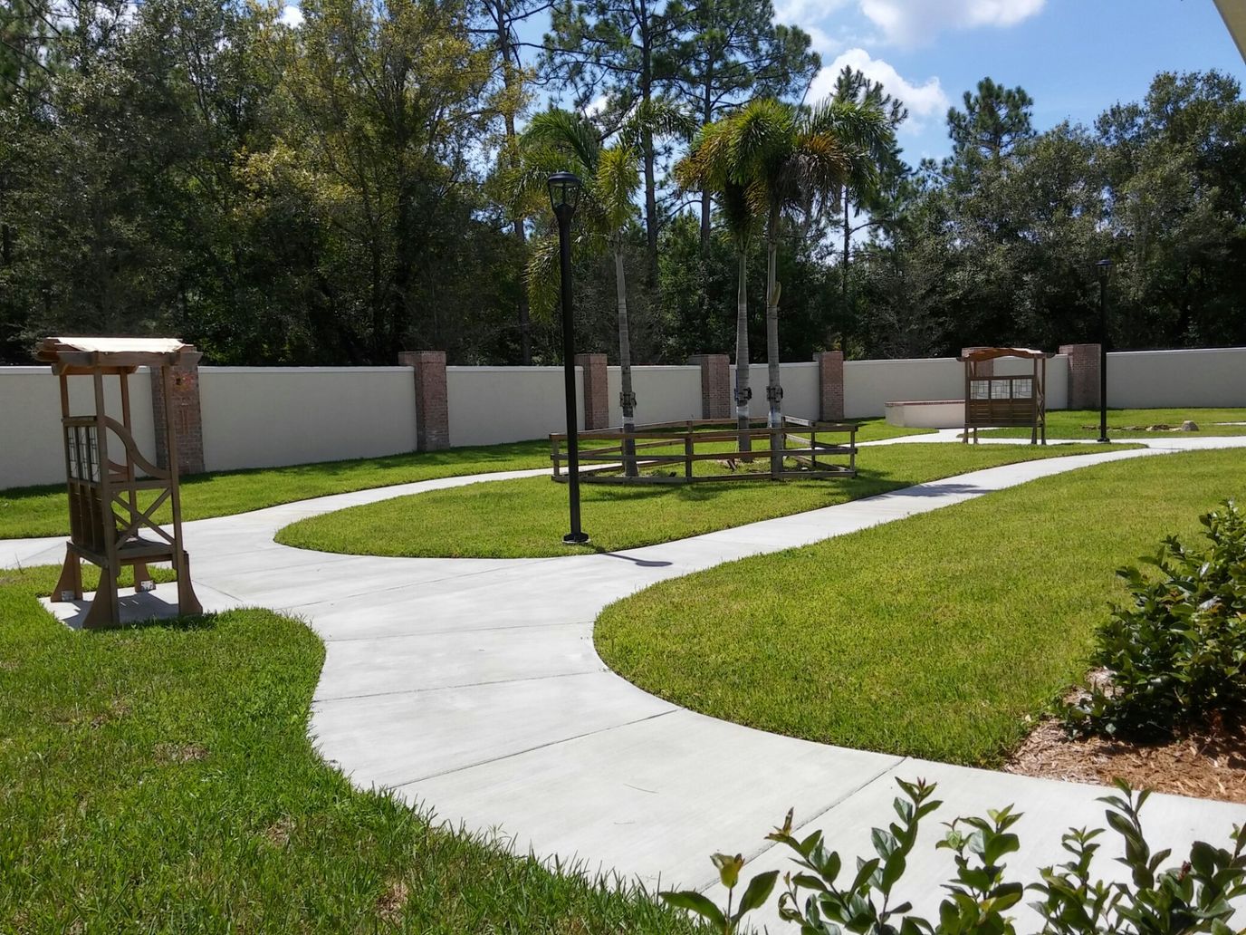 Curved pathway through a landscaped garden with palms