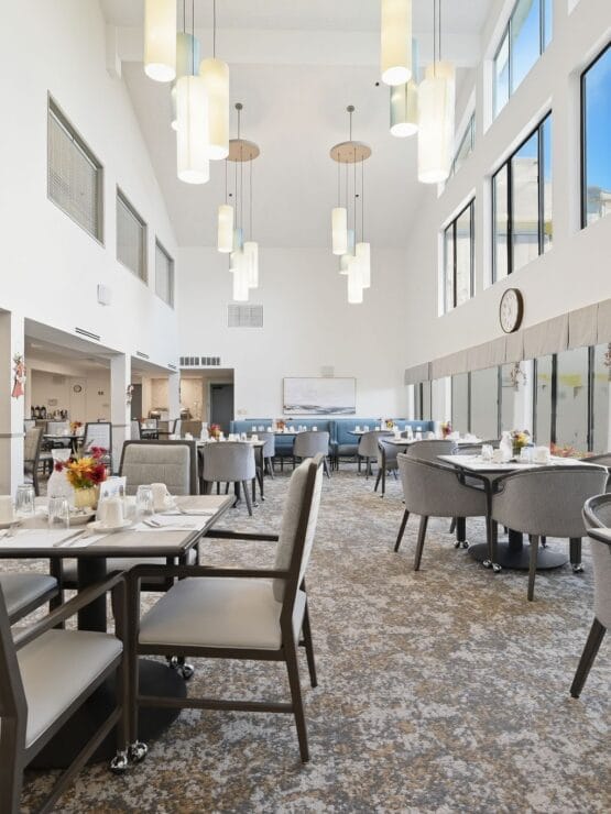 Modern dining area with large windows and tables set for meals.