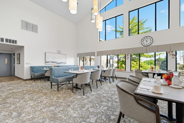 Bright dining room with large windows and tables set for meals.