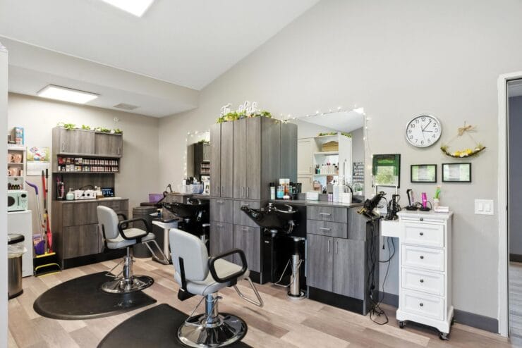 Hair salon area with styling chairs and mirrors.