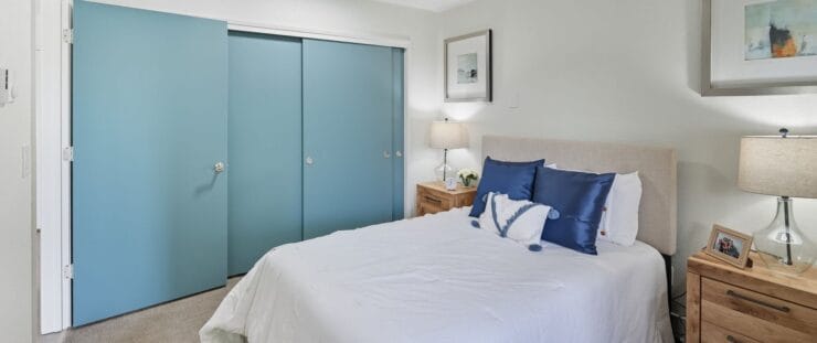 Cozy bedroom with blue accents and warm lighting.