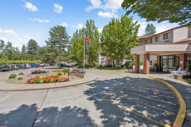 Exterior view of assisted living facility with flower beds.