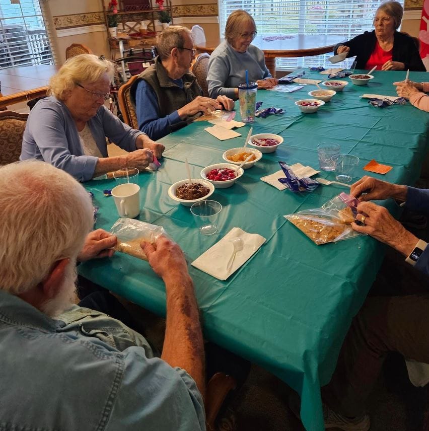 Seniors participating in a table activity with snacks.
