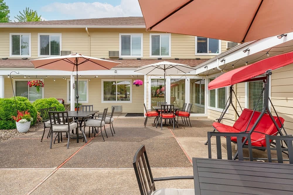 Outdoor seating area with umbrellas and plants at Brookdale Heritage Plaza