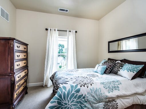 Cozy bedroom with floral bedding and wooden dresser