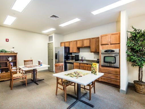 A bright common area with tables and kitchen amenities