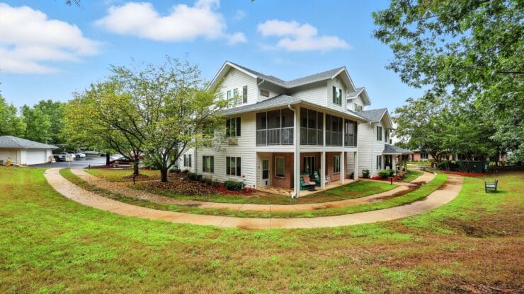 Exterior view of assisted living facility surrounded by greenery