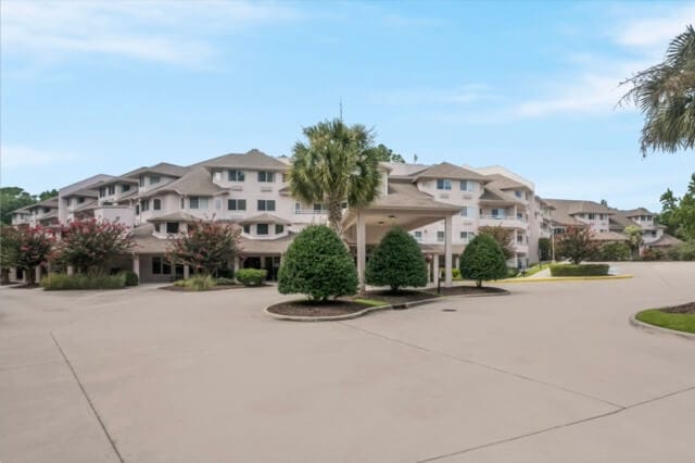 Exterior view of a senior living facility with gardens