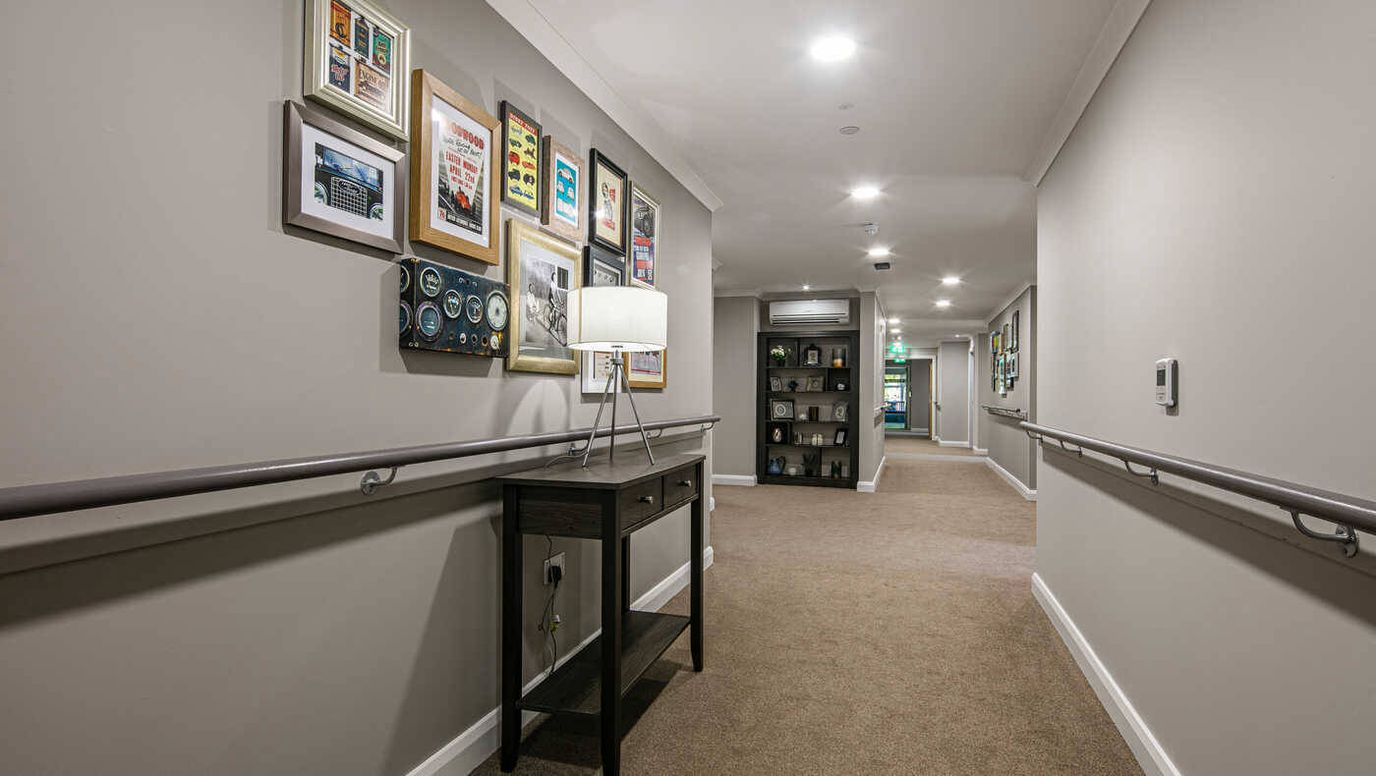 Bright interior hallway with framed art and seating