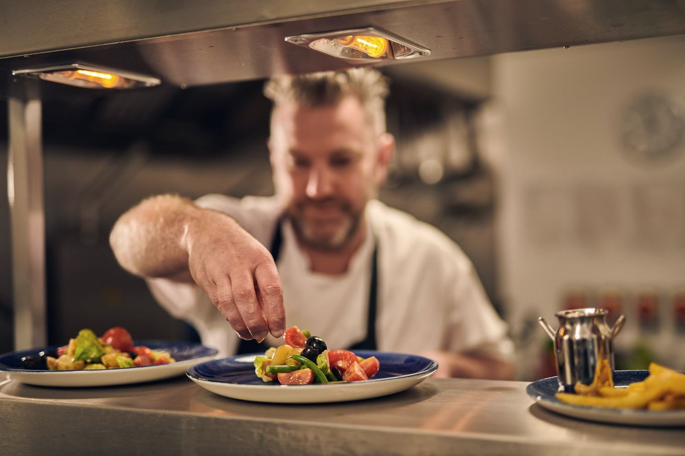 Chef plating a colorful dish in the kitchen