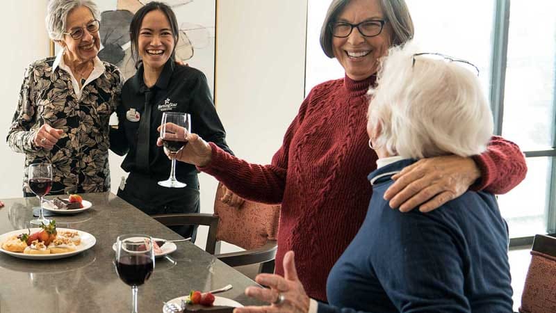 Residents enjoying wine and conversation in a communal area