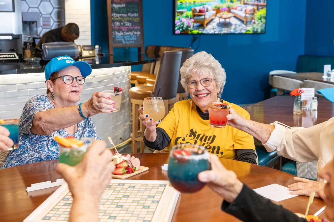 Residents toasting with colorful drinks in the common area