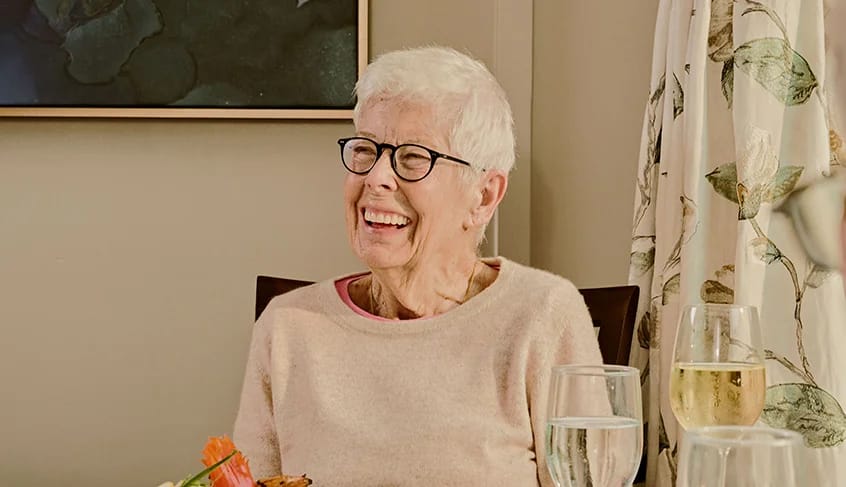 Smiling elderly woman enjoying a meal