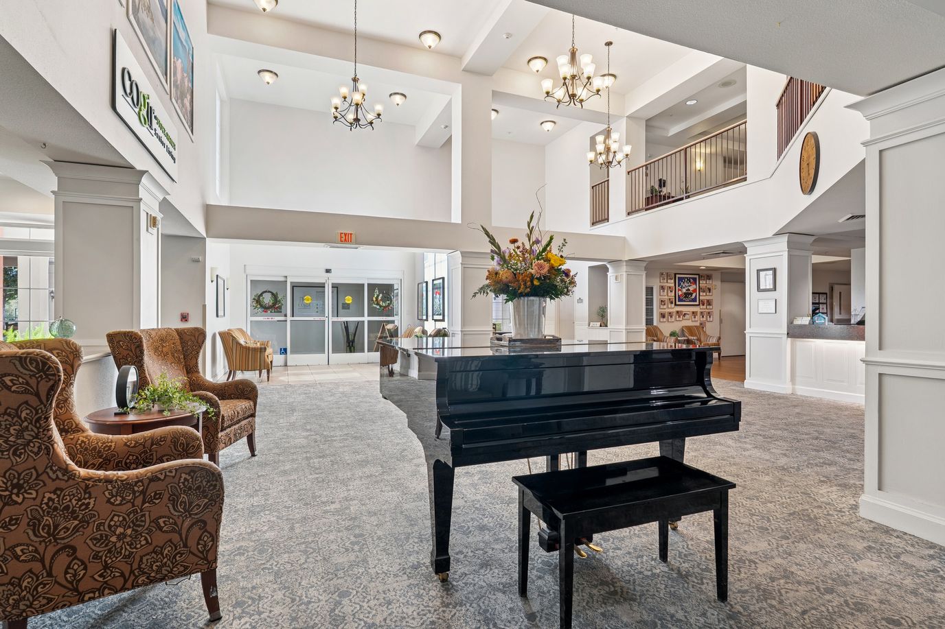Bright lobby featuring a piano and floral arrangements
