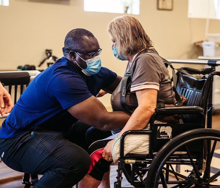 Staff assisting a resident in a wheelchair