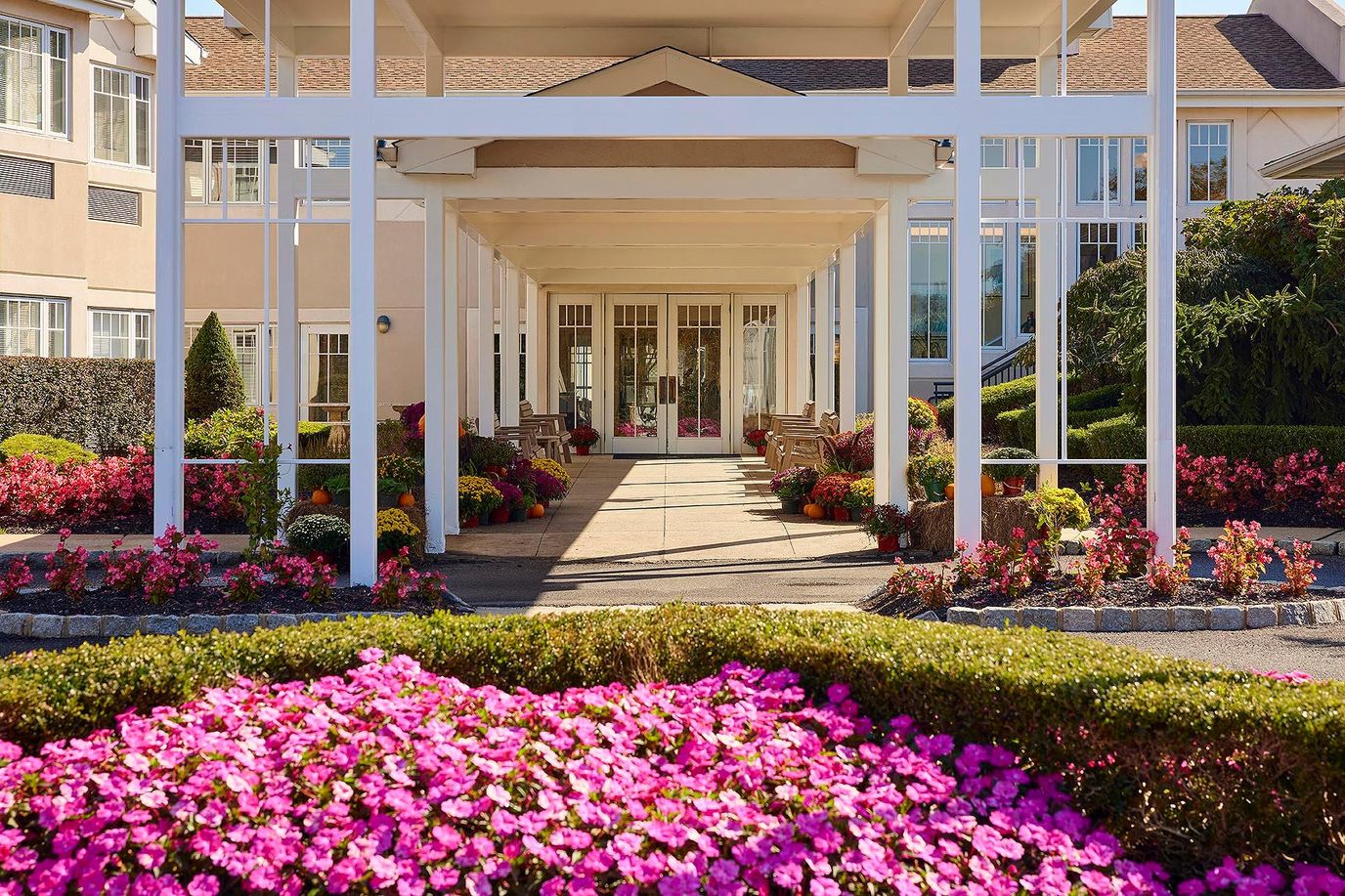 Entrance of a senior living facility with flower beds