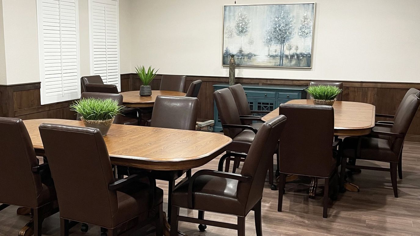 Common area with tables and chairs arranged for activities