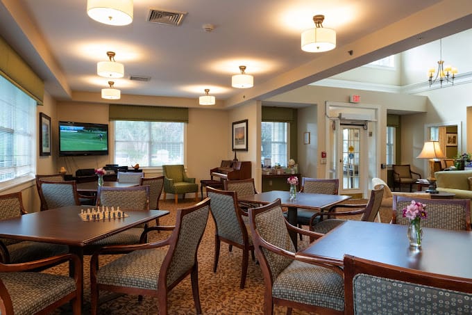 Common area with seating, chess table, and TV in The Cottages of Dartmouth Village.