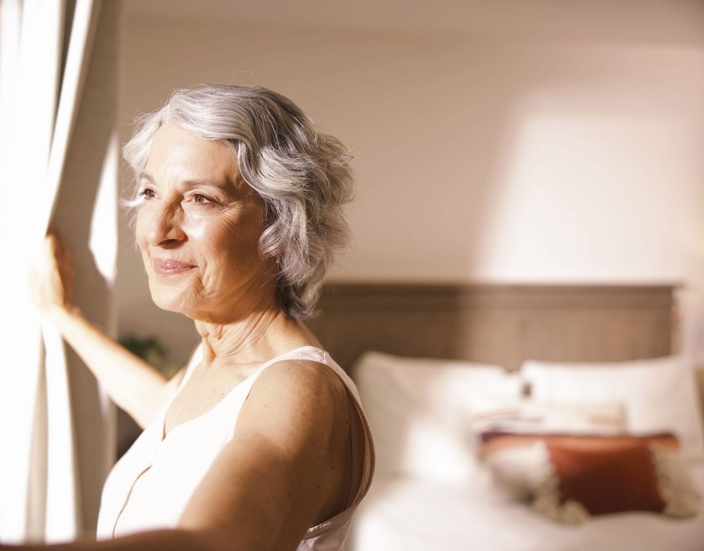 A smiling senior woman enjoying a bright room