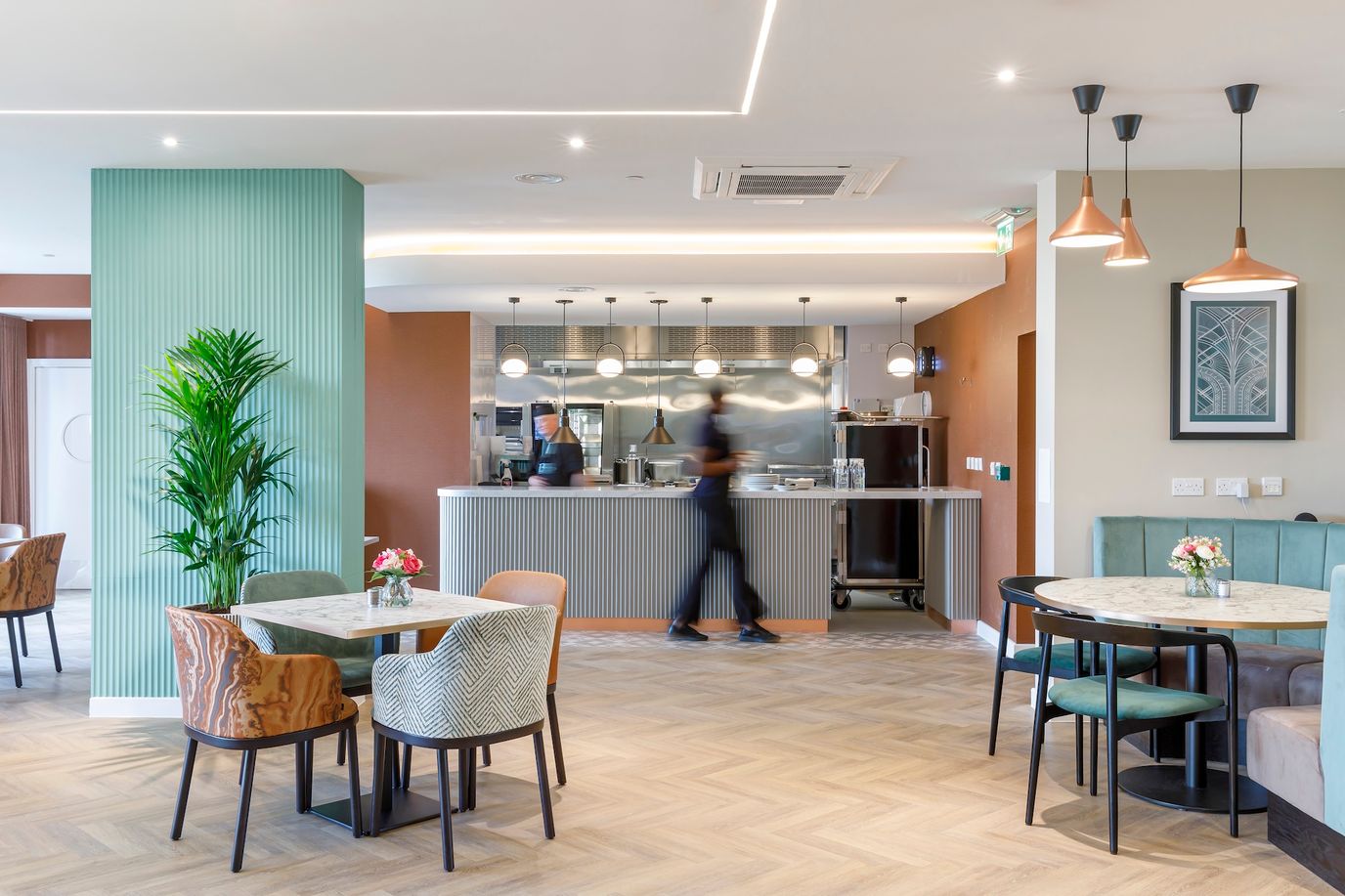 Interior view of a dining area with staff and plants