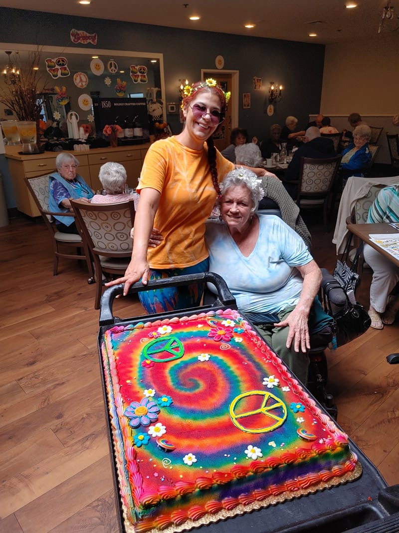 Staff member with resident and a decorated cake