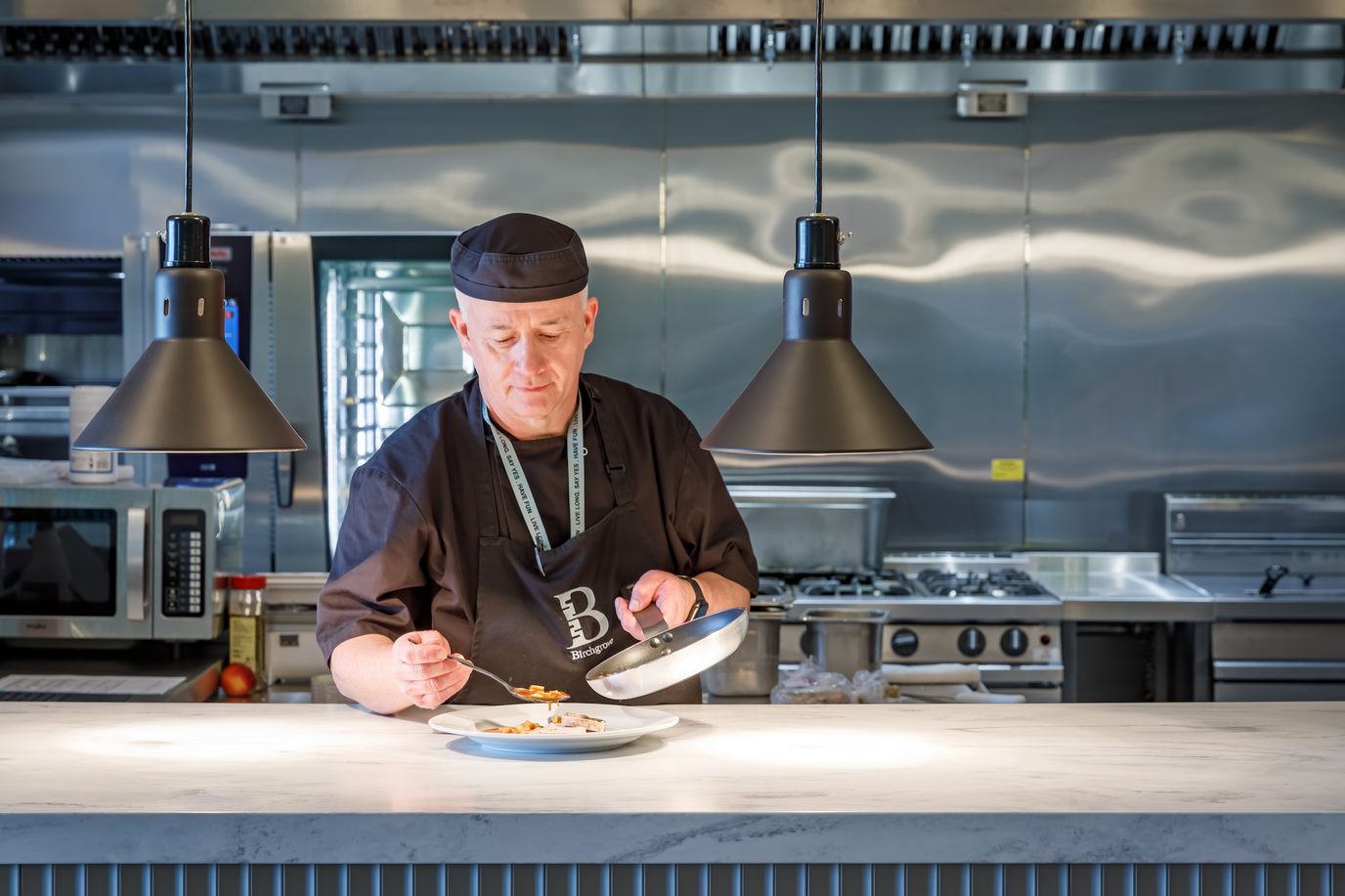Chef plating a dish in a modern kitchen