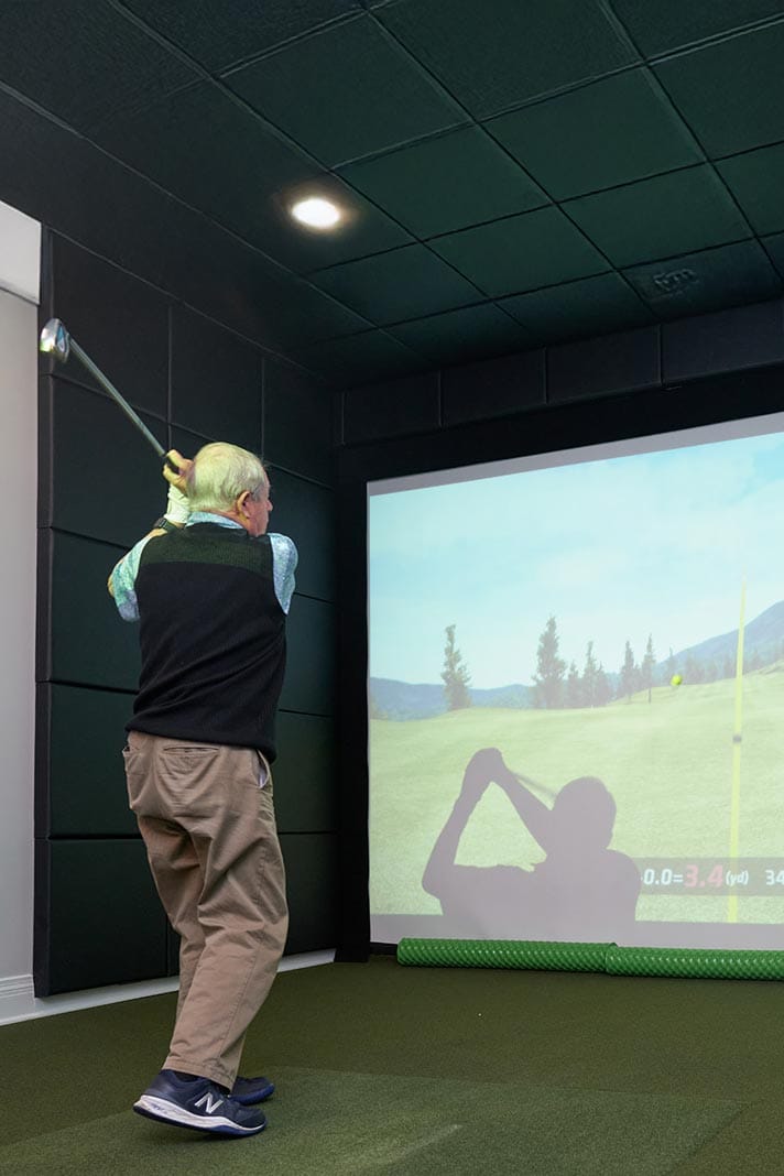Resident enjoying an indoor golf simulation activity