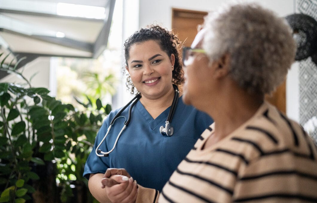 Nurse interacting with an elderly resident indoors