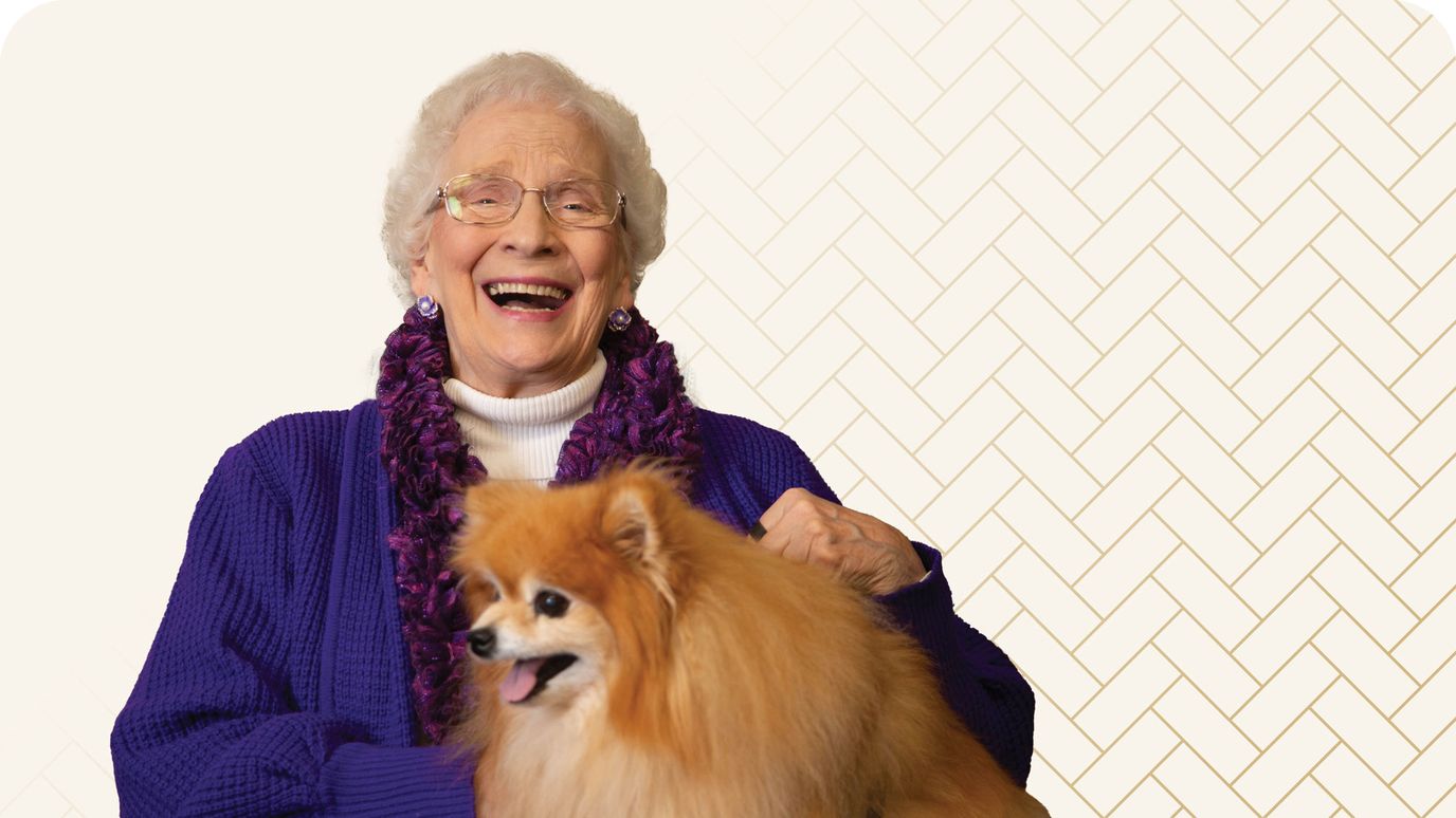 Elderly woman smiling with a dog.