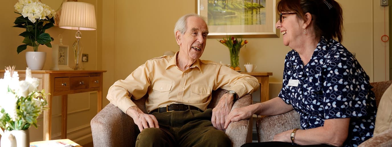 Senior resident and staff member in a cozy room