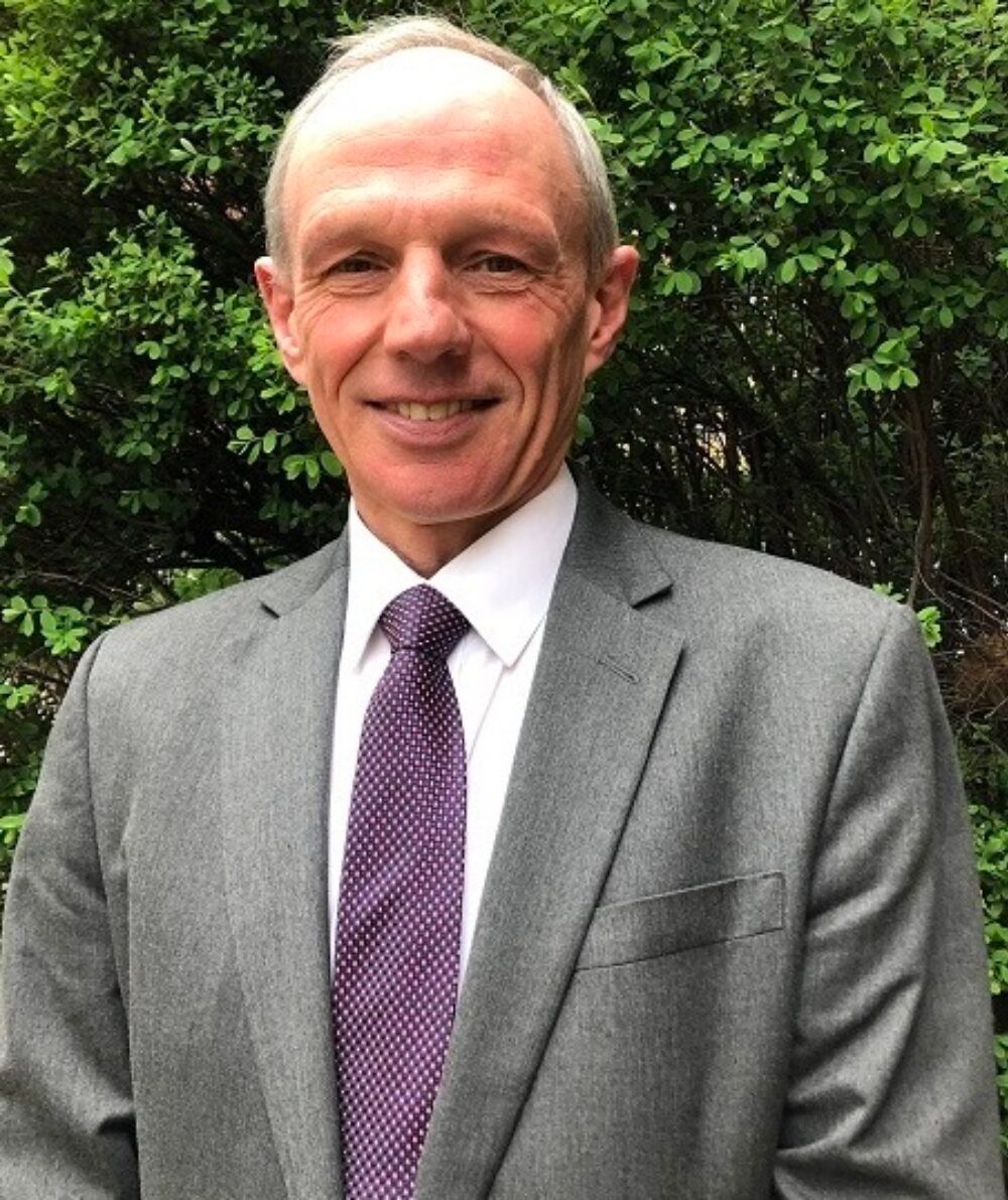 Smiling man in a suit standing outdoors