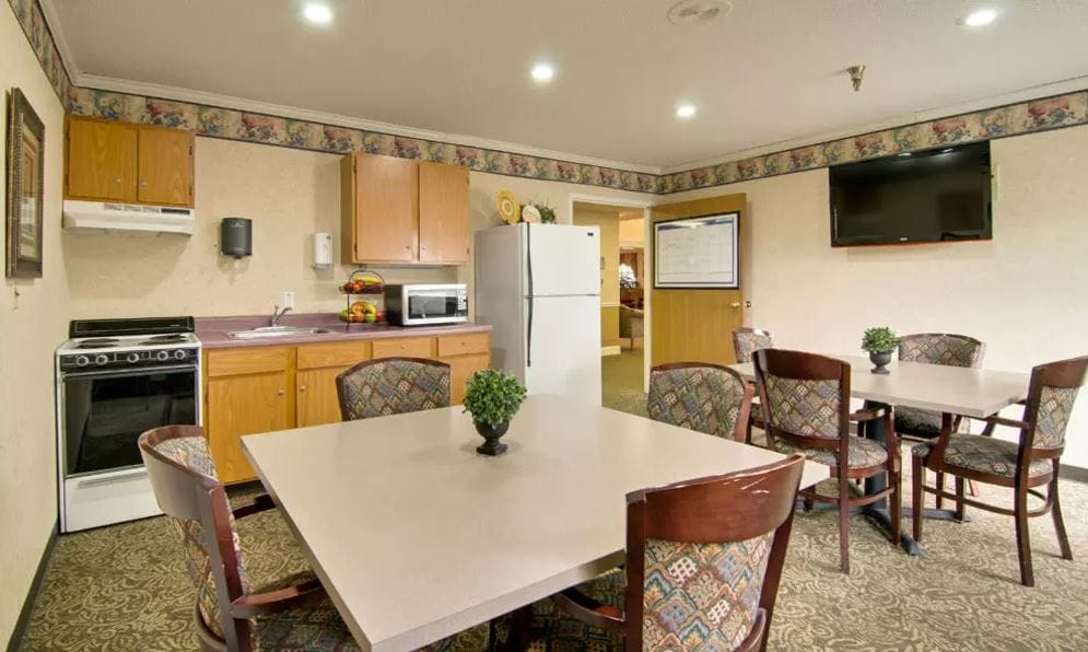 Interior of a common area featuring a kitchenette and dining table at Heritage Nursing Center.