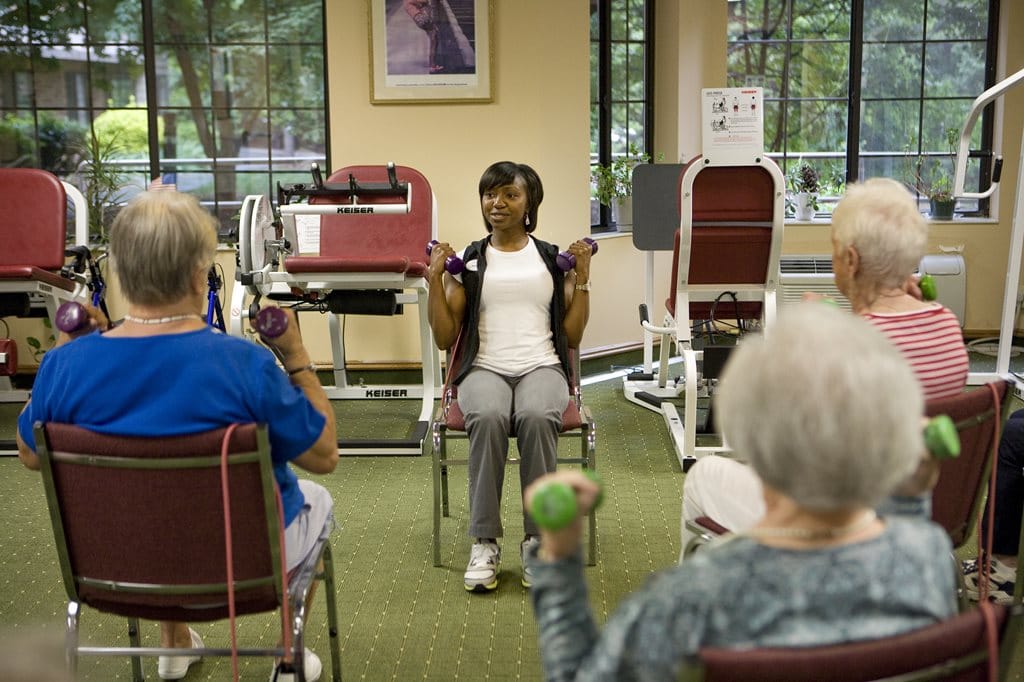Seniors participating in a guided exercise class with weights