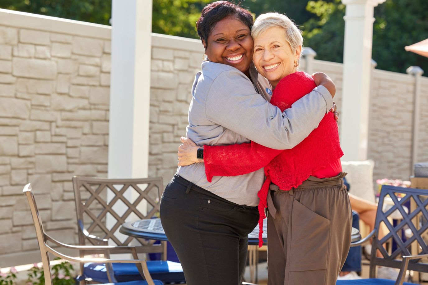 Two women hugging outdoors in a caring environment