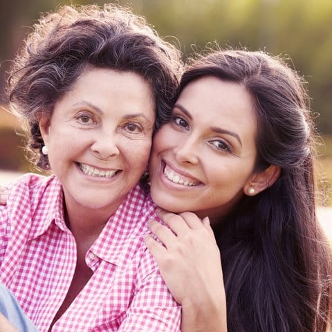 Smiling woman with her grandmother outdoors